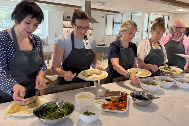 students-sharing-finished-dish Five students serve themselves a buffet-style meal they prepared from scratch.